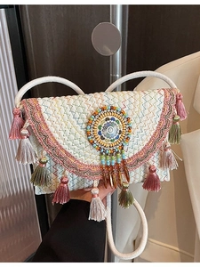 Handcrafted bohemian knit crossbody bag with colorful fringes and beaded ethnic charm