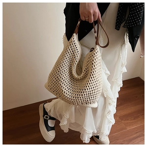 Detailed close-up of ivory woven mesh tote with dark brown leather shoulder strap