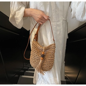 Dettagli della borsa a secchiello in paglia boho con perline di legno e nappa