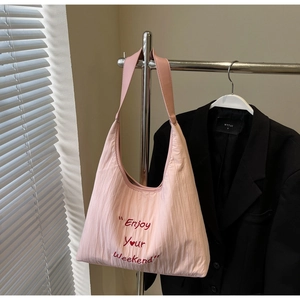 Detail of pink embroidered tote bag featuring Enjoy YOUR Weekend text and pleated texture