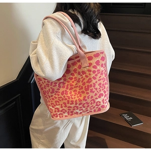 Detail of a large canvas tote with pink and orange leopard print and braided handles