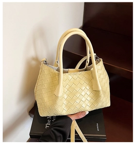 Détail du sac à main tissé jaune clair avec bandoulière amovible et texture tressée