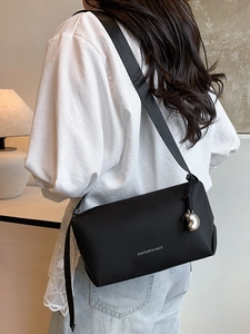 Sac à bandoulière noir minimaliste avec pendentif en cœur et large sangle réglable