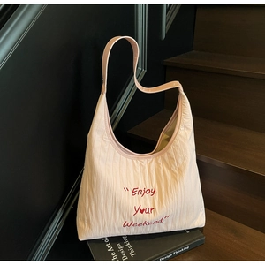 Detail of light pink tote bag with red Enjoy Your Weekend embroidery and heart