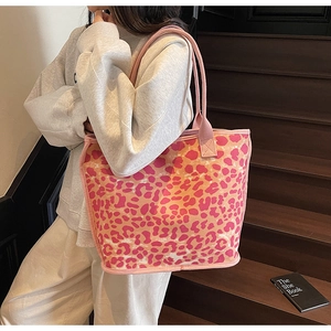 Pink leopard print canvas tote bag shown on shoulder in a stylish indoor setting