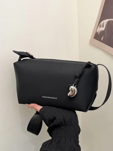 Sac bandoulière noir minimaliste avec pendentif argenté et sangle large