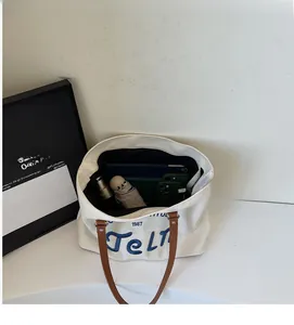 Interior view of large canvas tote bag with brown handles showing ample storage space