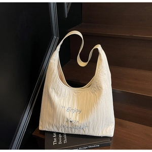 Detail of off-white tote bag with Enjoy Your Weekend embroidery and pleated texture