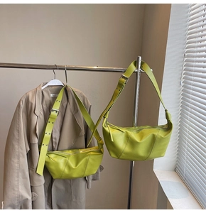 Detail view of avocado green half-moon crossbody bag in lychee pattern synthetic leather
