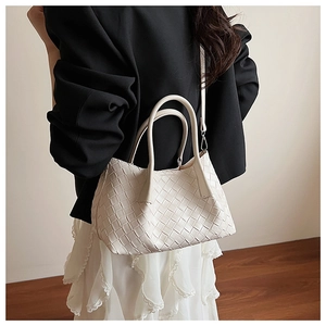 Détail de la texture tressée blanche et des poignées doubles de ce sac à main chic