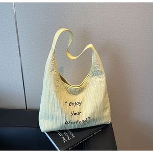 Detail of cream yellow pleated tote bag featuring Enjoy Your Weekend text print