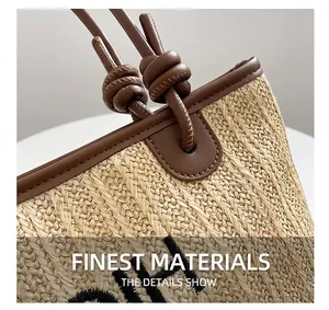Detail shot of the woven straw tote bag with brown leather trim and knot handle strap