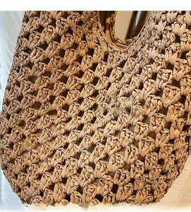 Close-up of the intricate hand-woven hollow patterns on this natural beige straw tote bag