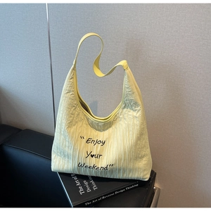 Detail of light yellow pleated canvas tote bag with Enjoy Your Weekend embroidery