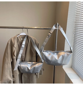 Detail of silver metallic dumpling bags with wide shoulder straps in a modern city style