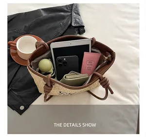 Detail showing the large capacity of a beige straw tote bag with brown leather handles