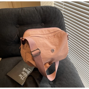 Détail du sac bandoulière en nylon rose poudré avec zips multicouches et sangle