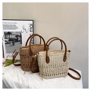 Detail of hand-woven straw tote with leather handles and drawstring lining on white cloth