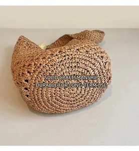 Detailed close-up of the reinforced hand-woven base on this straw shoulder beach tote