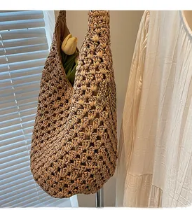 Detail of hollow woven straw shoulder bag with beige fabric lining and bohemian texture