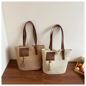 Close-up of woven straw tote bags with leather handles and tassel wood bead charms