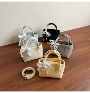 Close-up of litchi leather bucket bags in five colors with pearl chain and silk bows