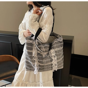 Détail du grand sac cabas gris avec dentelle blanche et bandoulière noire sur modèle