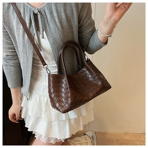 Vue détaillée du sac seau en cuir tressé main marron foncé avec texture croisée
