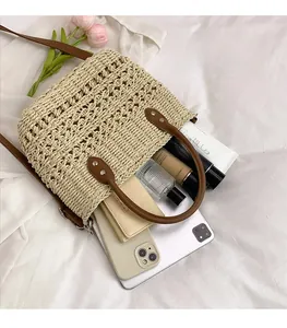 Top view of large straw tote bag showing spacious interior with phone and tablet