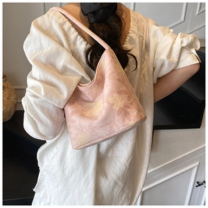 Detailed close-up of pink floral jacquard hobo bag with elegant textured leaf patterns