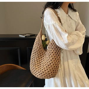 Detail of hollow woven straw bucket bag showing intricate mesh texture and beige handcraft