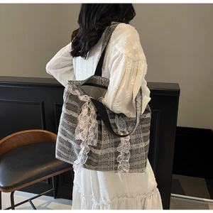 Détail du sac cabas gris à carreaux avec dentelle blanche et grand nœud élégant