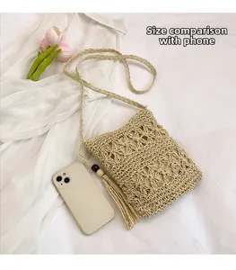 Detail showing hand-woven hollow pattern bucket bag with tassels and phone for size reference