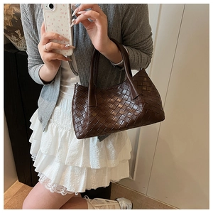 Selfie miroir montrant la taille du sac seau en cuir tressé marron foncé avec poignées