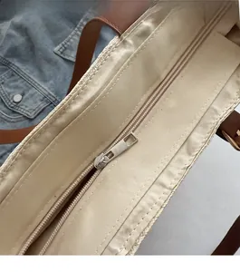 Detail view of smooth silver zipper and interior lining of the large woven tote bag
