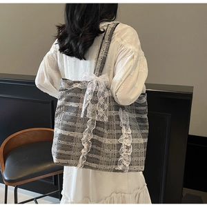 Détail du grand sac cabas avec bordure en dentelle et grand nœud décoratif translucide