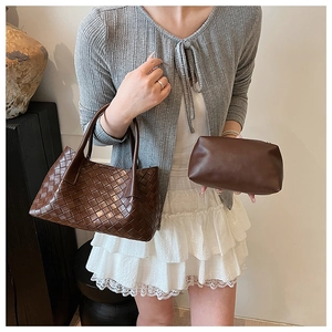 Détail d'un sac cabas en cuir tressé marron foncé et pochette assortie avec mannequin