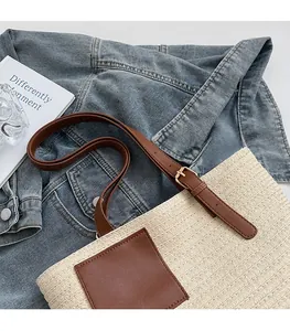 Close-up of adjustable brown leather strap and woven straw texture on the shoulder bag