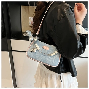 Vue détaillée du sac sous le bras en denim bleu clair avec garniture en PU rose