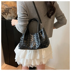 Détail du sac seau en cuir tressé noir avec artisanat Intrecciato et poignée ronde