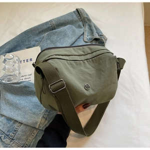 Sac bandoulière en nylon vert armée avec poches zippées et détail de large bandoulière