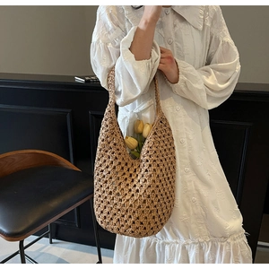Detail of hollow woven straw shoulder bag with natural texture and large capacity