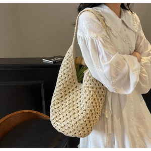 Detailed texture of beige crochet knit bucket bag with hollow woven pattern and strap