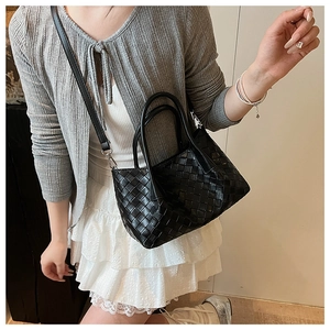 Détail du sac cabas noir tissé avec des finitions métalliques et une bandoulière