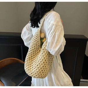 Detail of hollow woven shoulder bag showing natural fiber texture and hobo style shape
