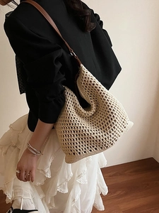 Beige hollow crochet straw tote bag with brown leather shoulder strap shown on model