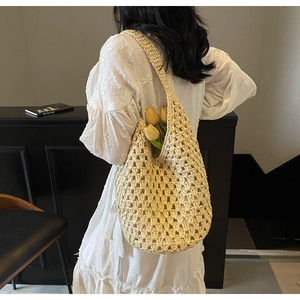Detail view of cream hollow out woven shoulder bag with intricate crochet pattern and texture