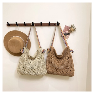 Detail of floral hollow crochet texture on straw tote bags with ethnic woven straps