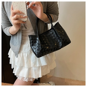 Détail d'un sac cabas en cuir noir tressé à la main avec motif carré classique