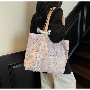 Détail du sac cabas rose clair à pois avec bordure en dentelle et grand nœud